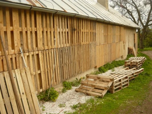 Kreatívne využitie paliet a pilín s hoblinami na zaizolovanie kamenného obvodového múru. Aj tu platilo, že materiál bol skoro zadarmo, ale časové náklady boli vysoké. FOTO - Archív autora
